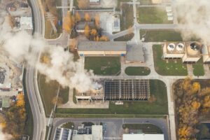 Factory plant releasing smoke into the air representing carbon emissions and carbon credits