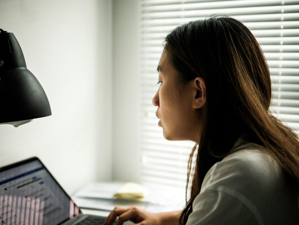 ESG reporting specialist working on sustainability data and compliance reporting on a computer